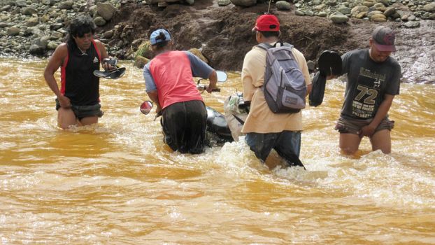 Arbeiter auf dem Weg durch einen mit Nickelrückständen belasteten Fluss